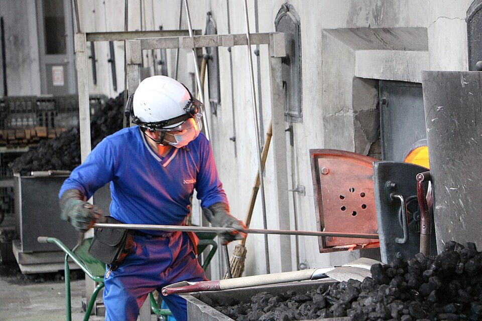 Worker adding coal to a pot still at Yoichi Distillery